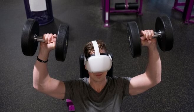 Person lifting weights with VR headset